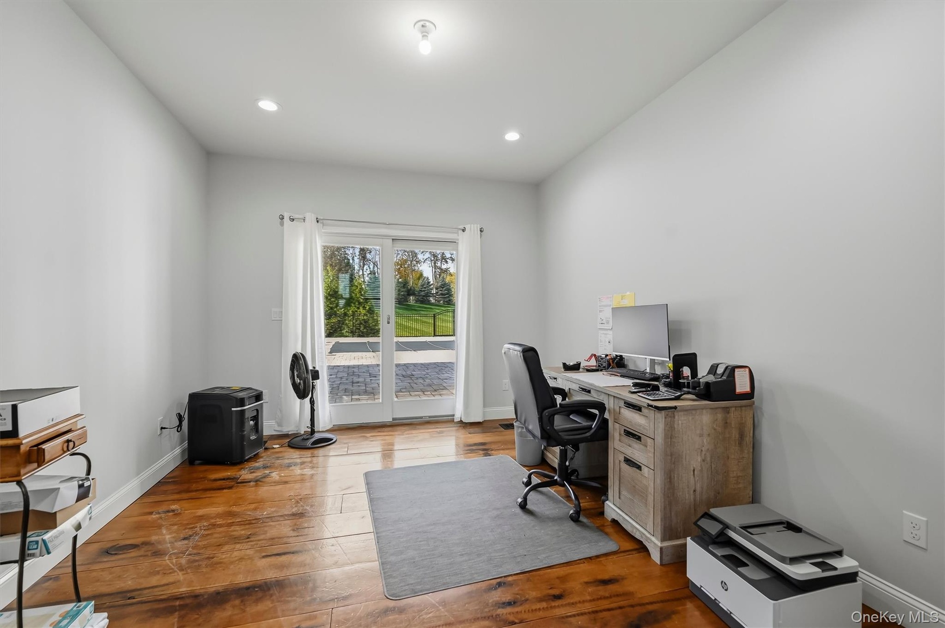 Room featuring wood-finish flooring, recessed lighting, and glass sliding doors to the patio