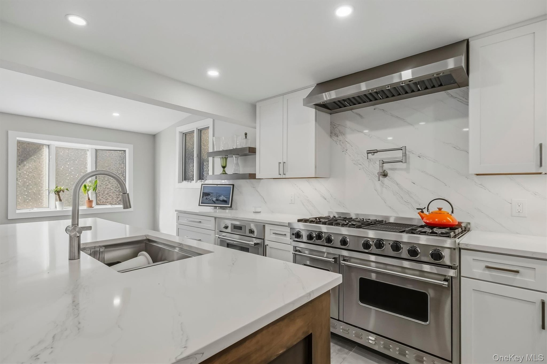 Gourmet chef's kitchen featuring top-of-the-line professional appliances, custom cabinetry, extensive counter space, and a large center island designe