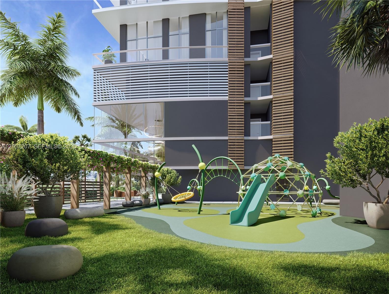 Outdoor recreational area featuring a structured play system with a slide, climbing dome, and rope swing, set within a landscaped space defined by a w