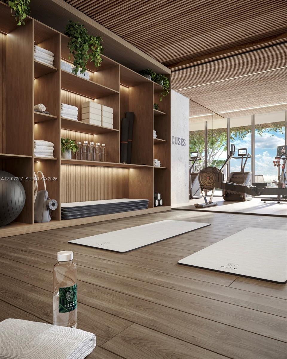 Yoga and pilates Floor-to-ceiling custom wood shelving with integrated LED lighting, linear wood-slat ceiling, wood-finish flooring, and expansive flo