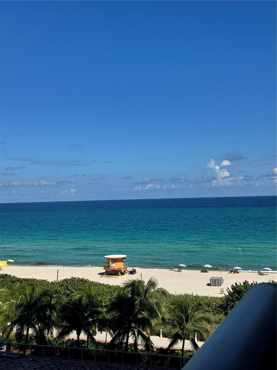 Direct oceanfront exposure with panoramic water scenery, sandy beach access, and lush palm foliage