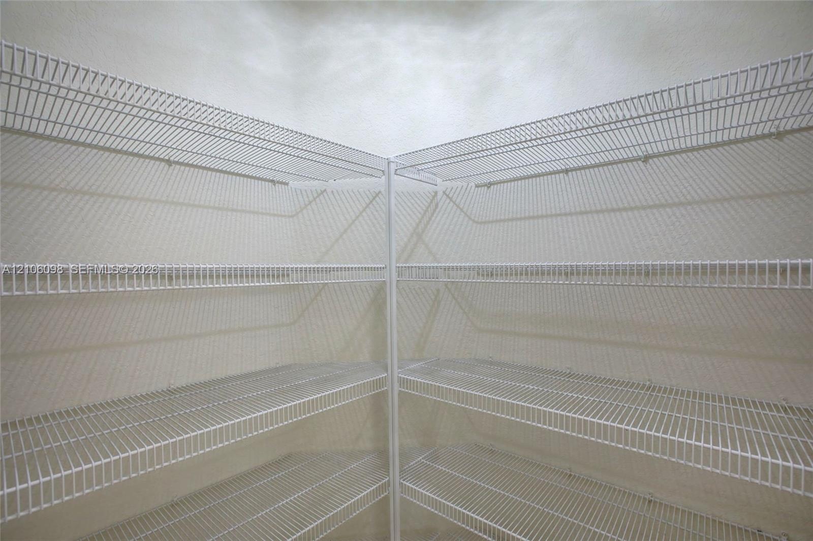 Corner storage area featuring white wire shelving across four tiers