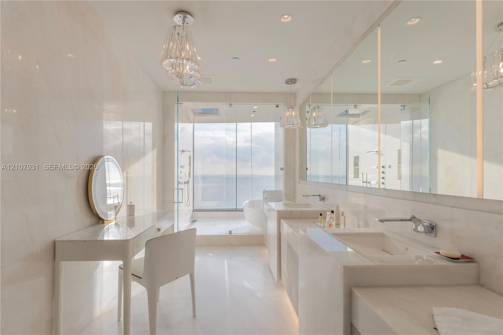 Bathroom featuring floor-to-ceiling stone wall cladding, dual integrated stone sinks, wall-mounted chrome faucets, glass-enclosed shower, and built-in