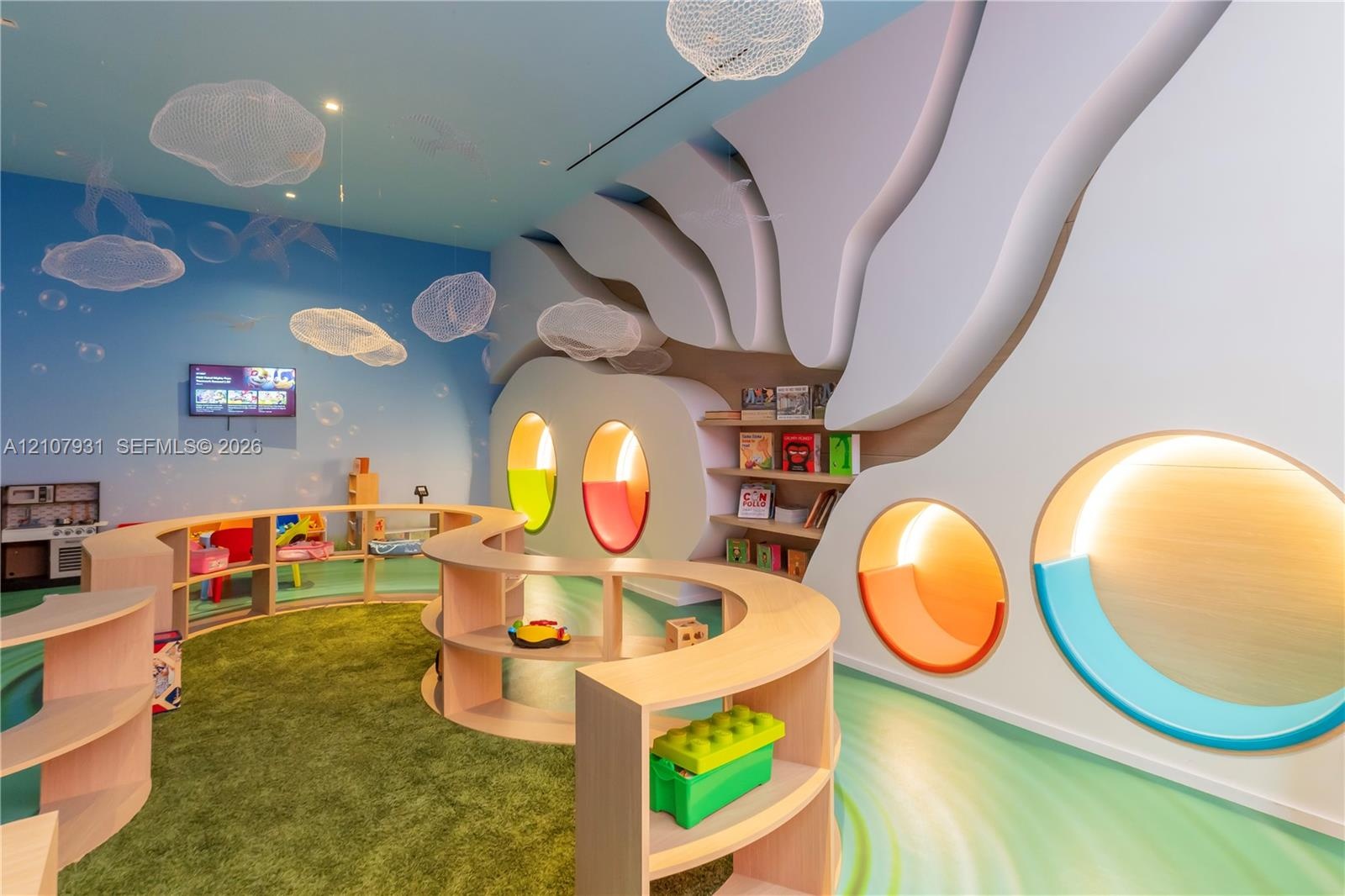 Custom interior featuring architectural wall treatments, built-in curved shelving units, recessed circular illuminated wall niches, and bespoke suspen