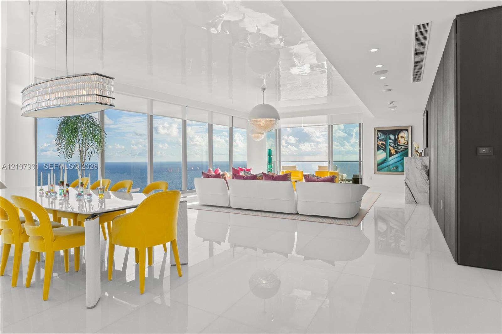 Open-concept interior featuring high-gloss flooring, floor-to-ceiling windows, panoramic ocean scenery, recessed lighting, and a crystal-accented chan
