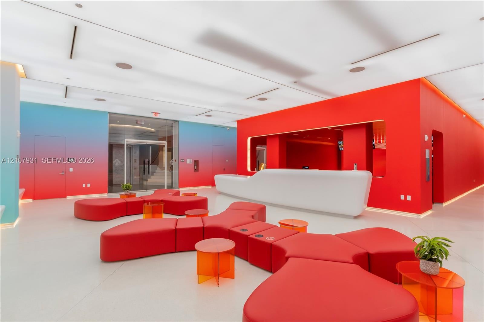 Contemporary lobby featuring a sculpted white built-in reception desk, high-gloss solid flooring, recessed linear lighting, and gradient-finished wall