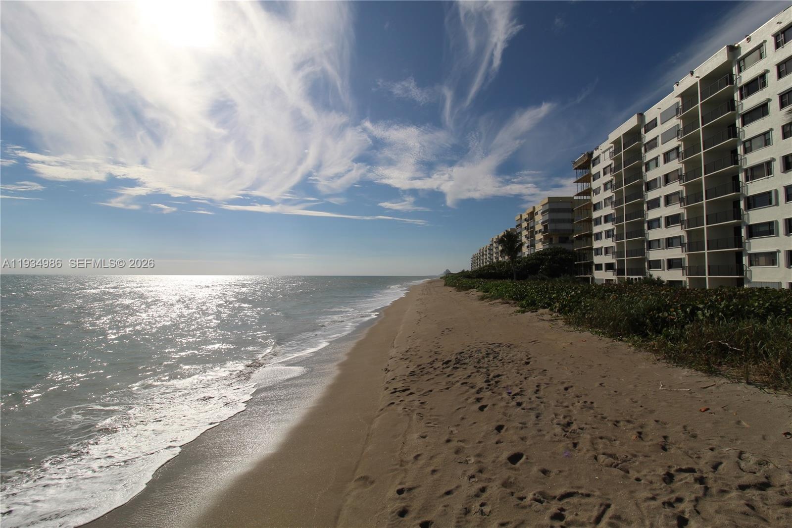 Coastal high-rise building with balcony access and direct shoreline frontage
