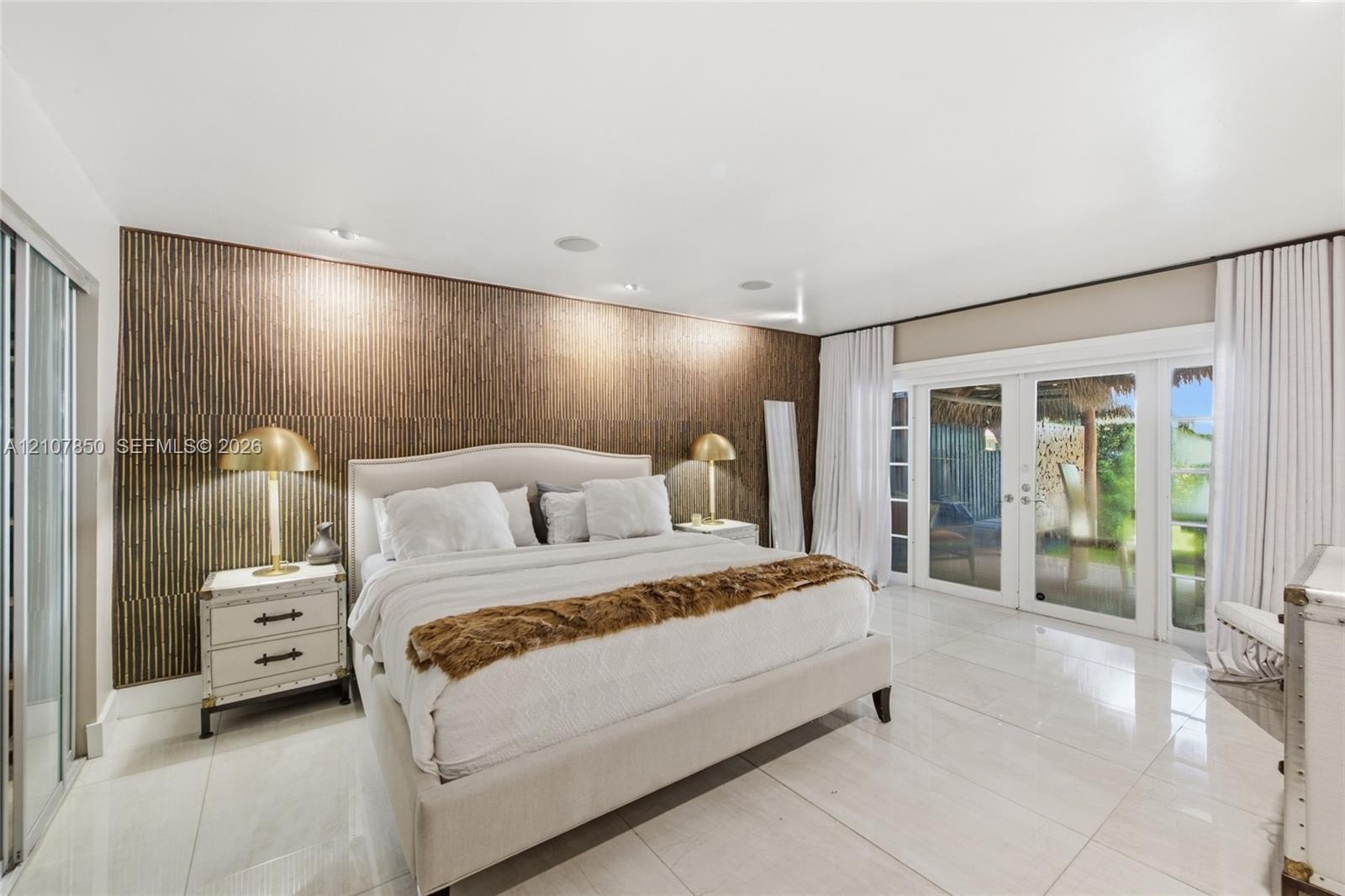 Textured wood-slat accent wall, polished large-format tile flooring, and glass-paned double doors with integrated window treatments