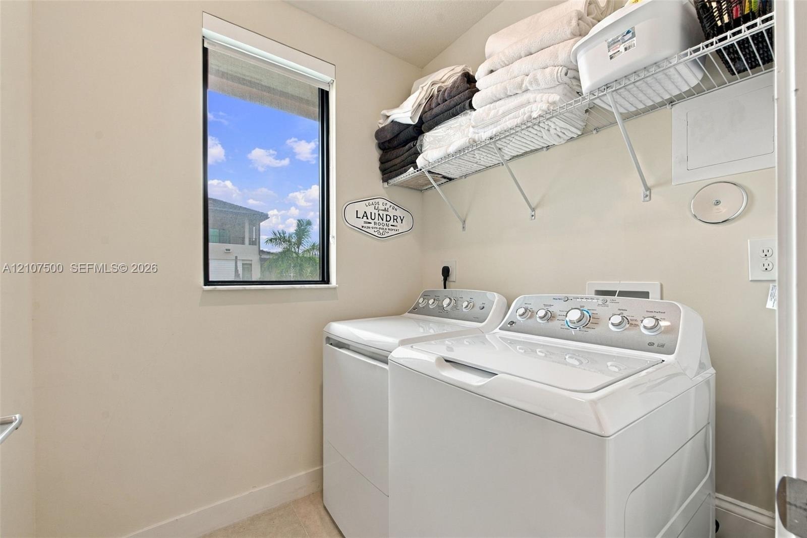 Laundry area featuring a window, built-in wire shelving, and appliance hookups