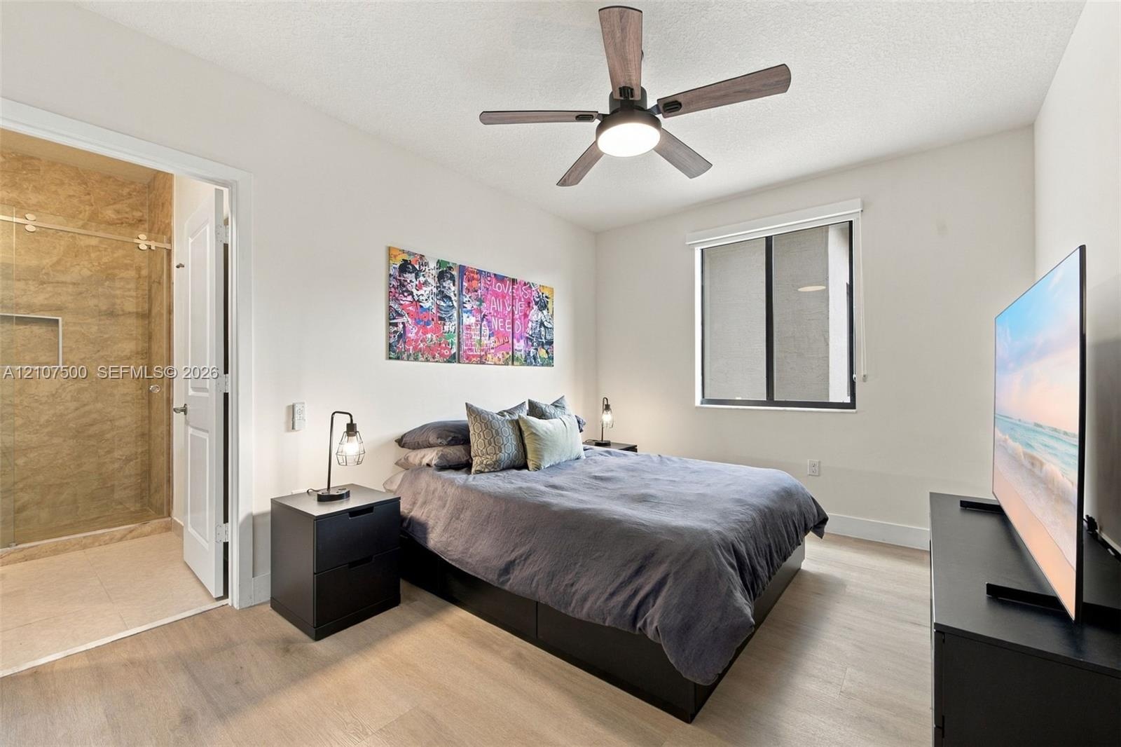 Bedroom featuring wood-finish flooring, a ceiling fan with integrated lighting, and a single-hung window