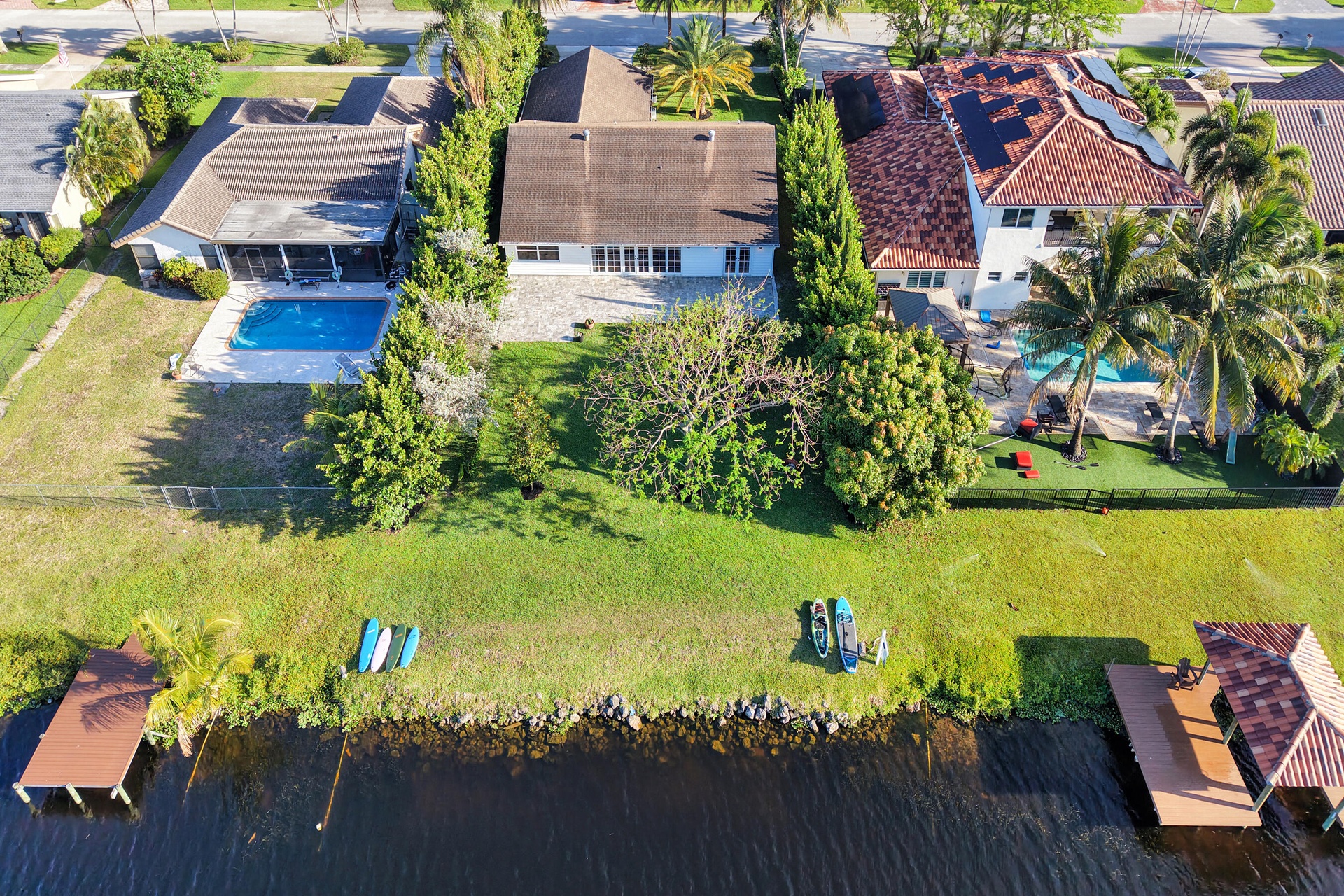 Neighborhood aerial. Pools and docks shown are on neighboring properties and are not included with this rental. Inland canal with fixed bridges and no