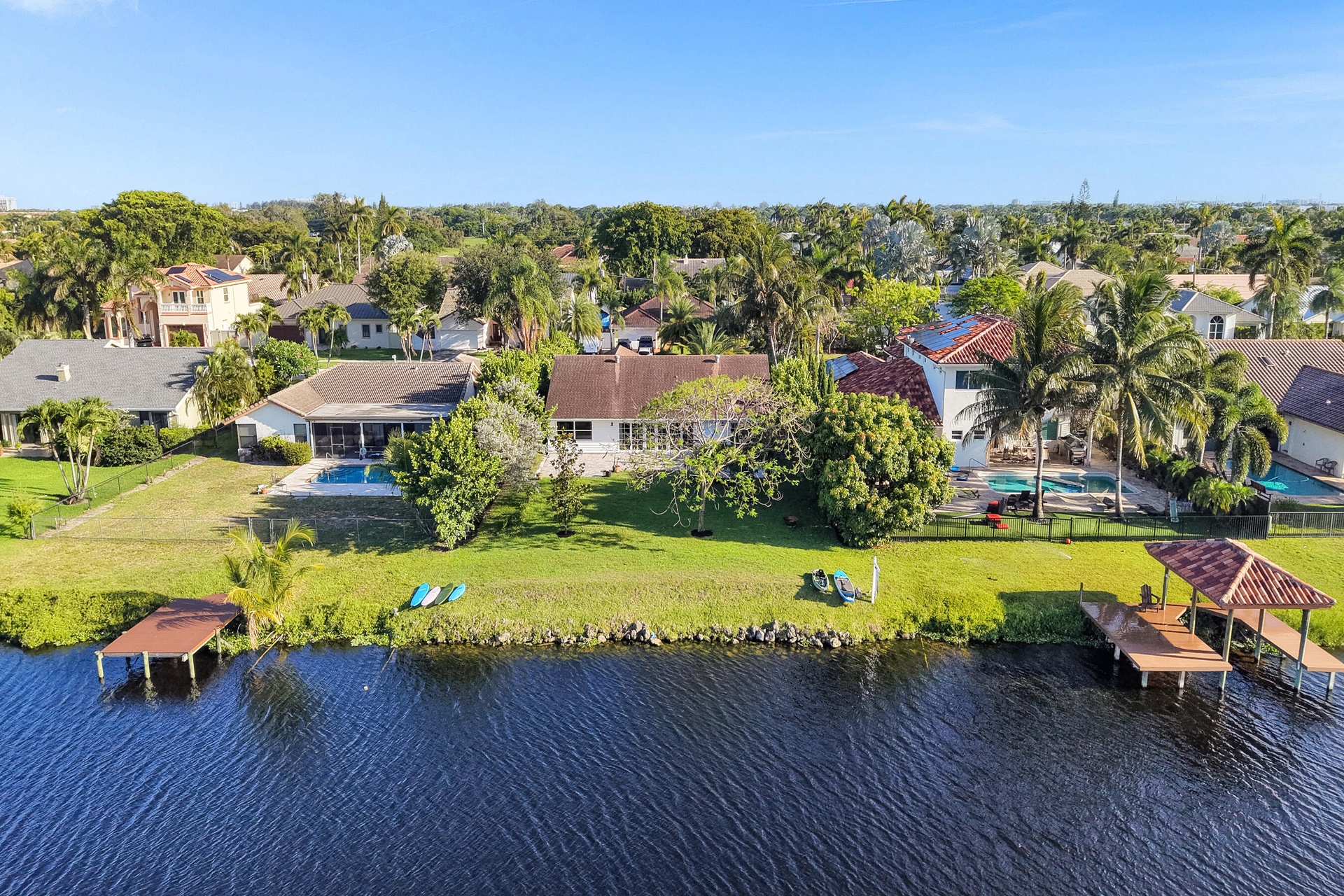 Neighborhood aerial. Pools and docks shown are on neighboring properties and are not included with this rental. Inland canal with fixed bridges and no