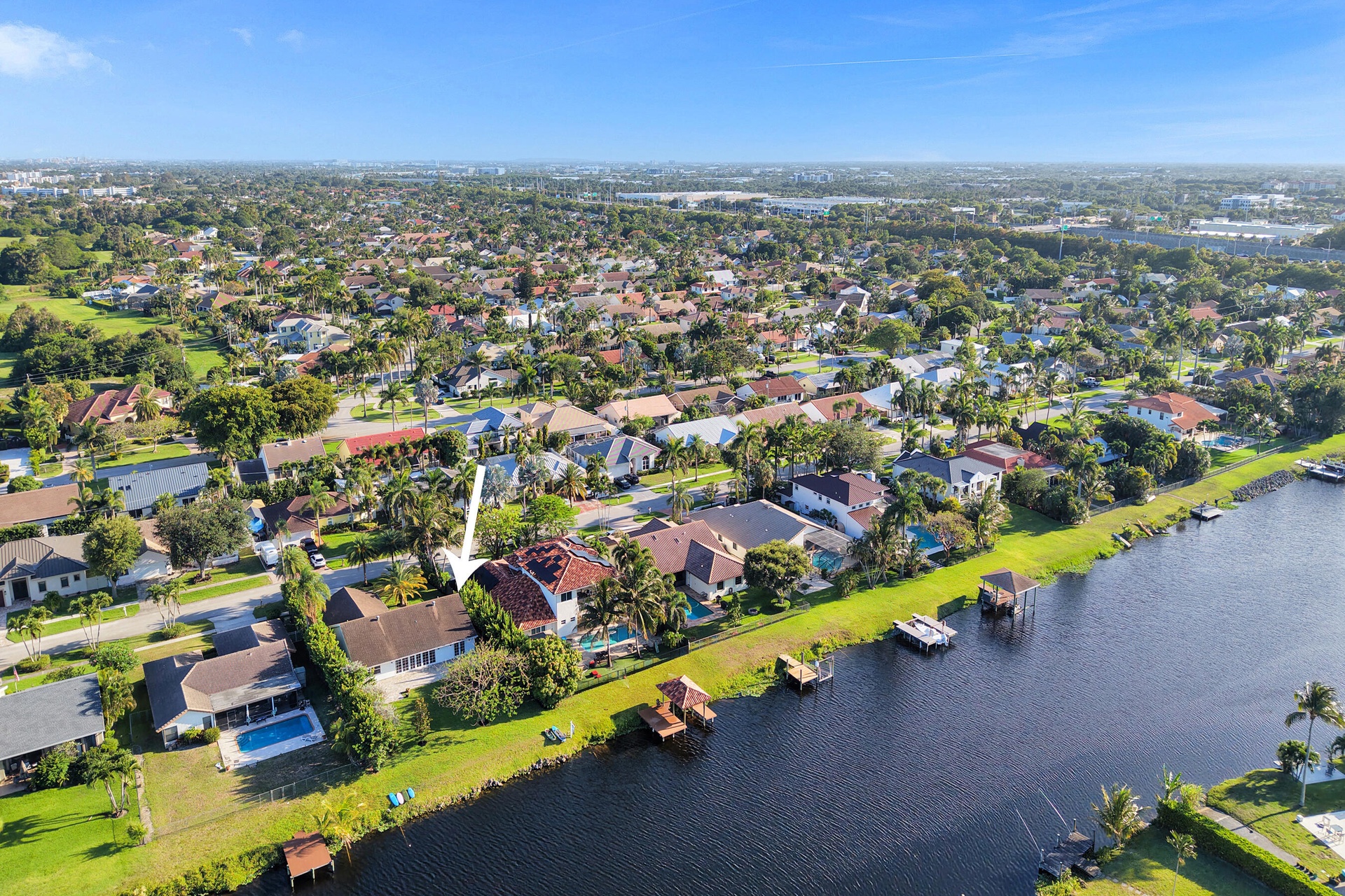 Neighborhood aerial. Pools and docks shown are on neighboring properties and are not included with this rental. Inland canal with fixed bridges and no