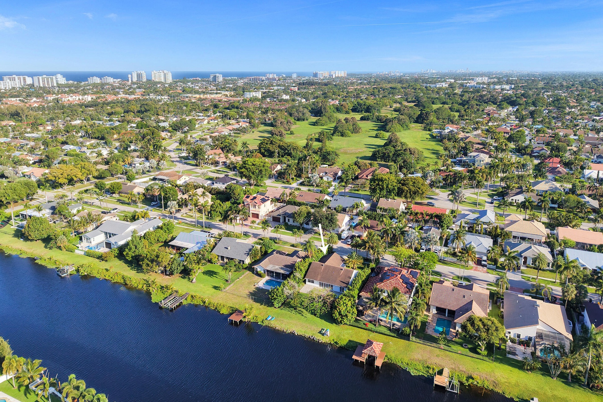 Neighborhood aerial. Pools and docks shown are on neighboring properties and are not included with this rental. Inland canal with fixed bridges and no
