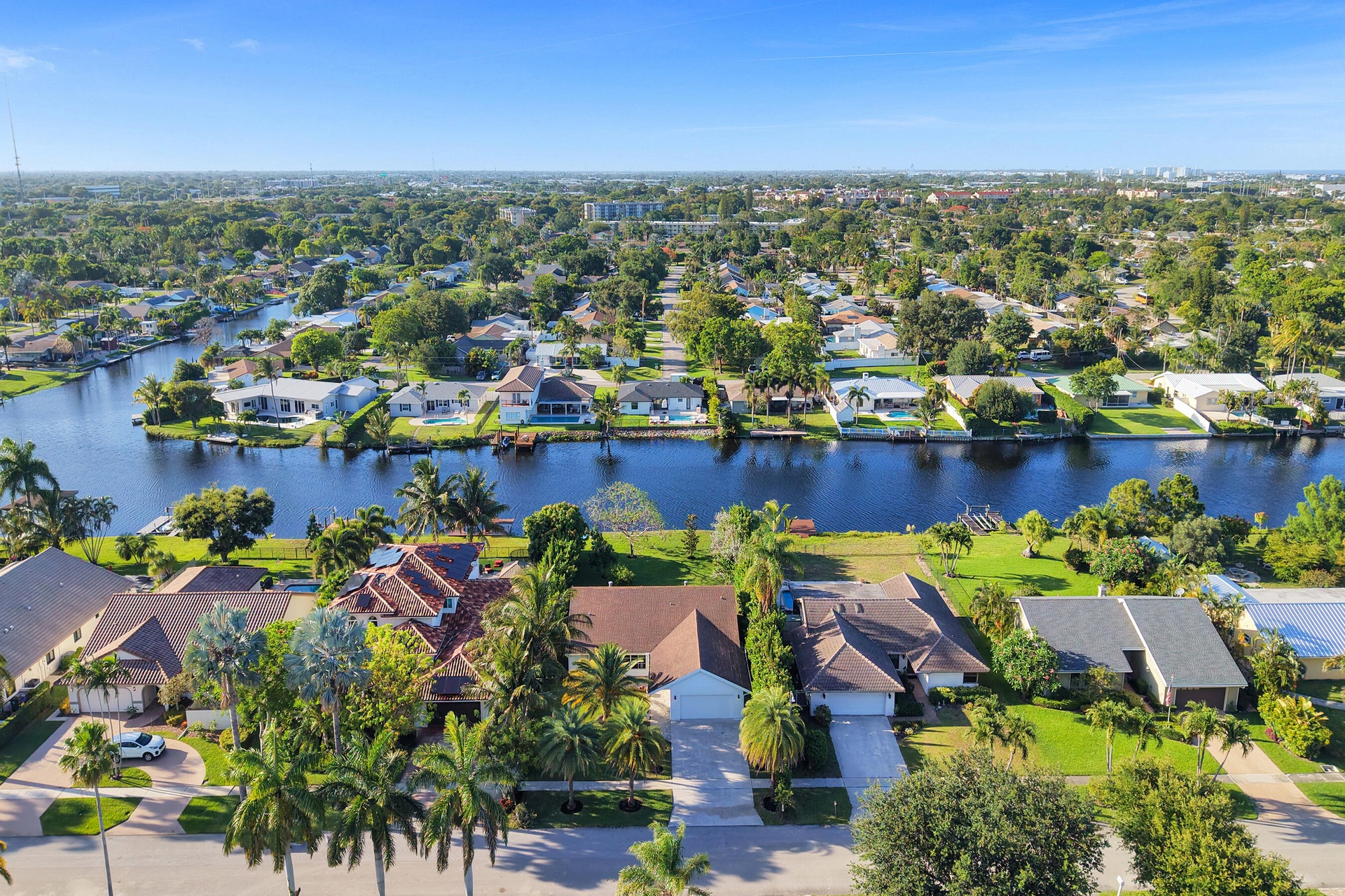 Neighborhood aerial. Pools and docks shown are on neighboring properties and are not included with this rental. Inland canal with fixed bridges and no