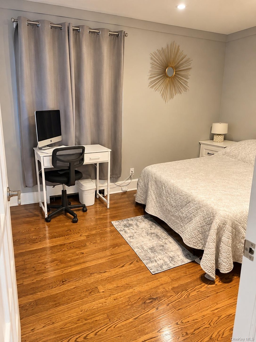 Neutral-toned interior room featuring wood-finish flooring and recessed ceiling lighting