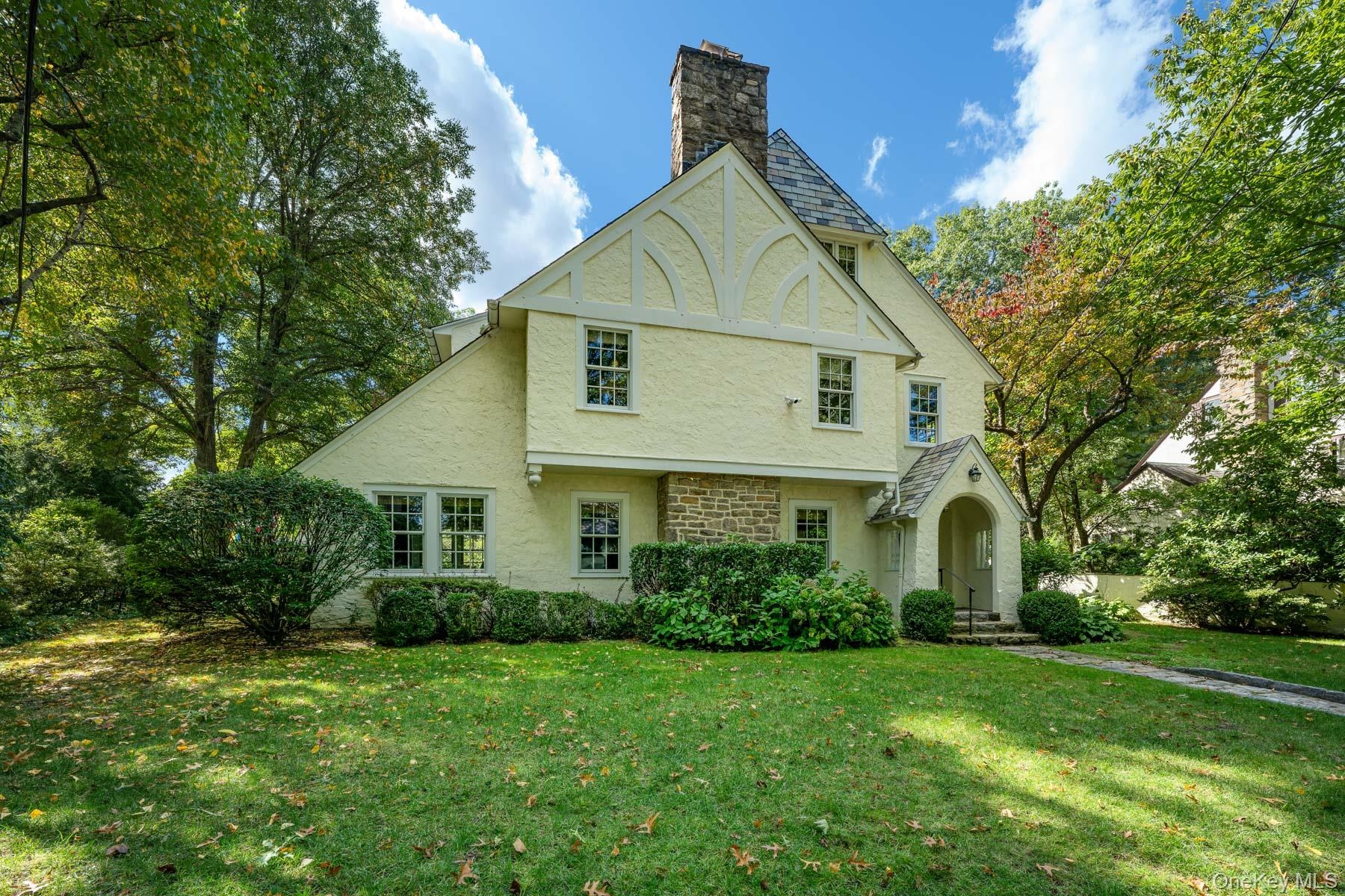 Looking at 49 Beechmont featuring mature landscaping, stucco exterior with wood details.