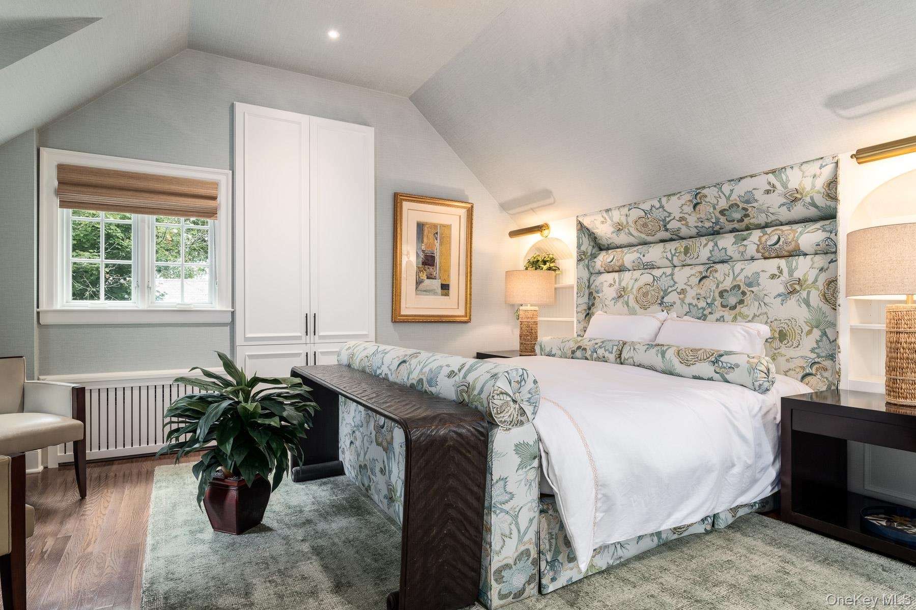 Sumptuous third level Primary Ensuite with custom bed, built-in cabinetry, hardwood floors and recessed lighting.