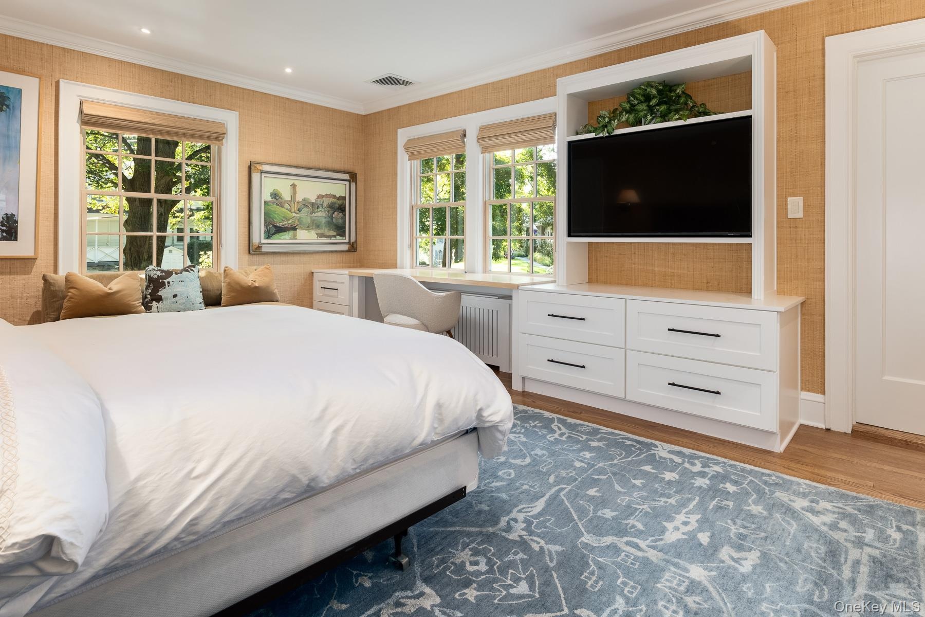 Additional view of the bedroom showing two exposures and built-in cabinetry.