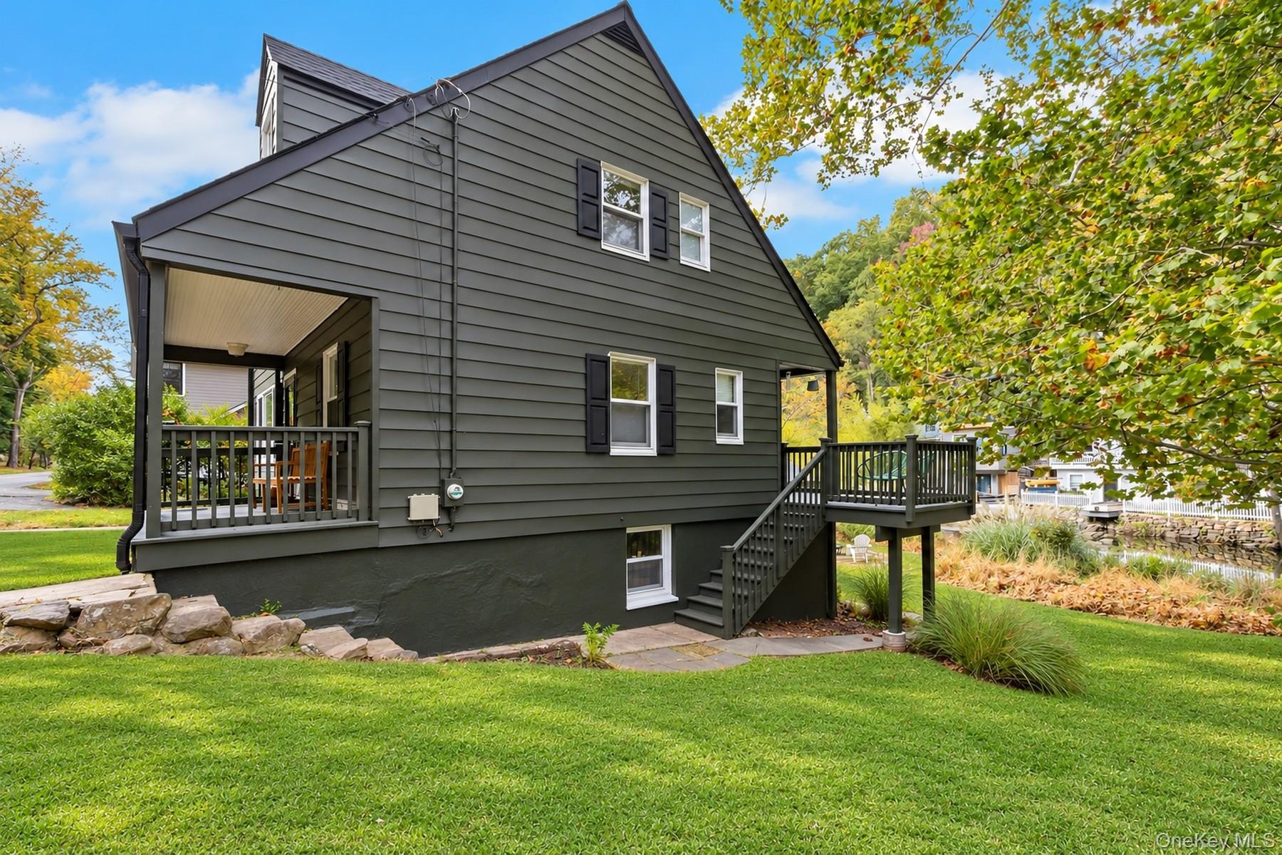 Side of home with view of covered porch and back deck