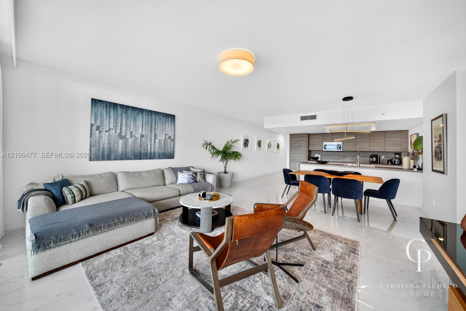 Open floor plan featuring polished stone-finish flooring, custom horizontal-grain cabinetry, quartz countertops, minimalist recessed lighting, and a m