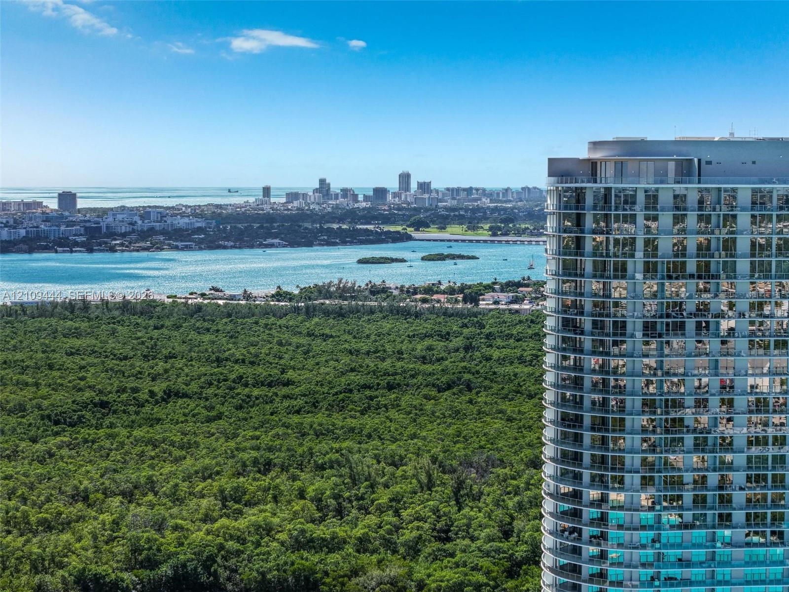 High-rise residential tower featuring floor-to-ceiling glass windows, wrap-around private balconies, and an exterior facade of glass and steel