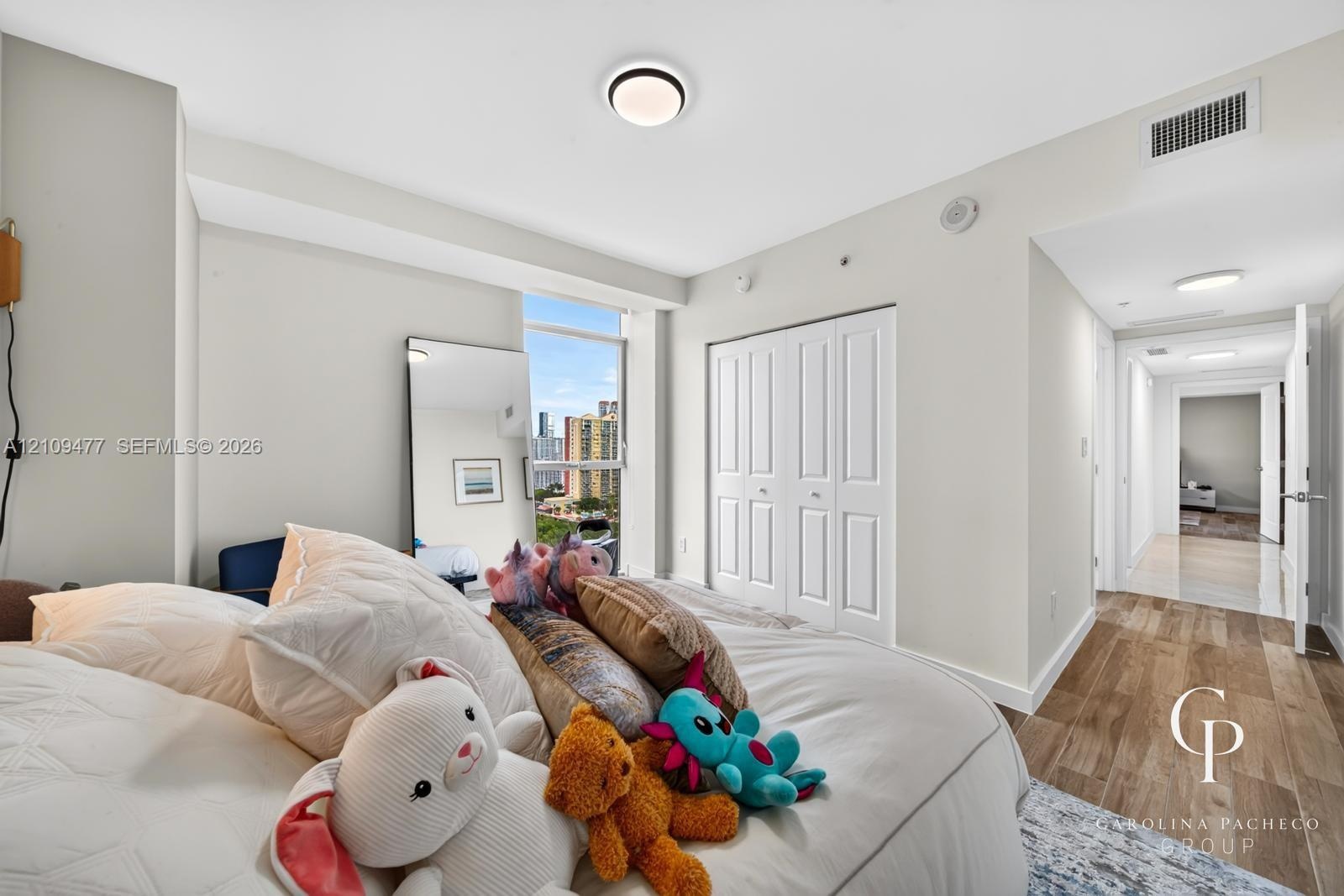 Interior space featuring wood-finish flooring, floor-to-ceiling windows, flush-mount ceiling lighting, and a double-door closet