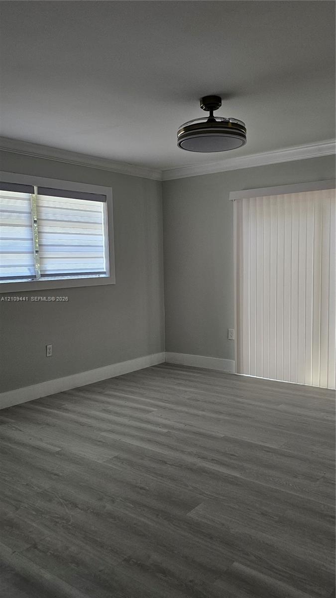 Interior room featuring wood-finish flooring, neutral wall tones, a recessed ceiling fan with integrated lighting, a sliding glass door, and a horizon
