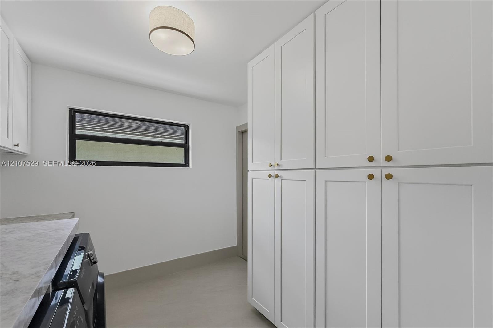 Neutral-toned tile flooring, multi-pane sliding closet doors, decorative multi-tiered pendant lighting, and recessed ceiling illumination