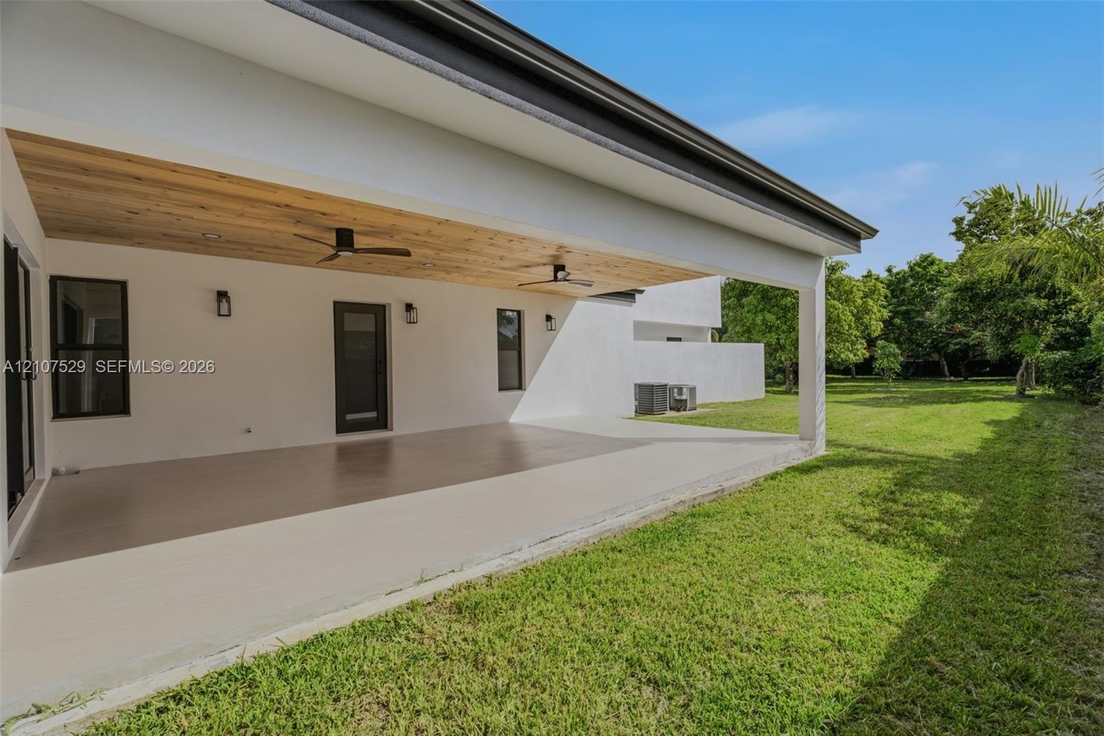 Covered patio featuring a wood-plank ceiling, large-format tile flooring, recessed lighting, ceiling fans, and sliding glass doors