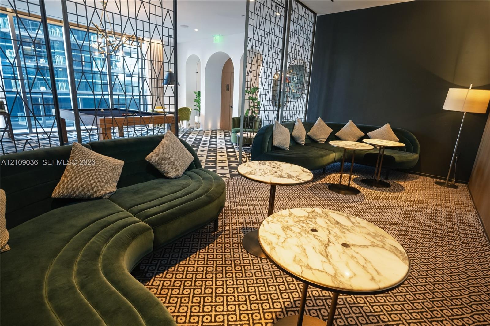 Common area featuring decorative metal room dividers, arched architectural alcoves, and patterned flooring