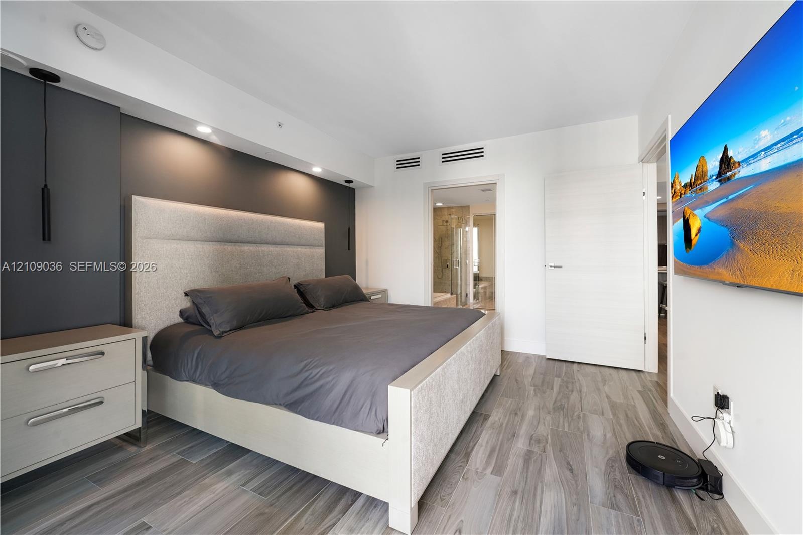 Wood-finish flooring, recessed ceiling lighting, dark accent wall, and horizontal-grain interior door
