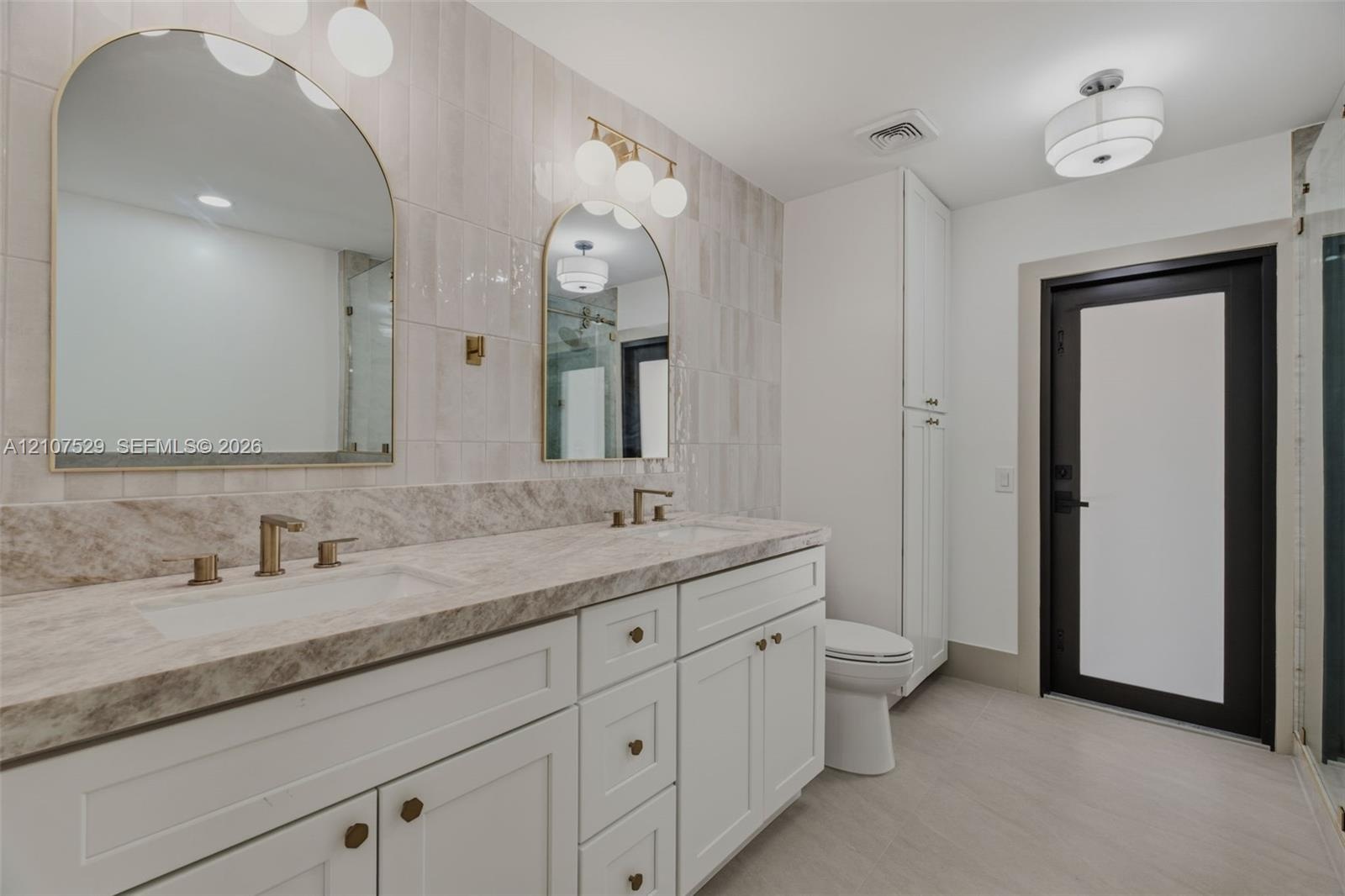 Interior space featuring light-toned tile flooring, neutral walls, a tiered crystal-style flush mount ceiling fixture, and recessed lighting