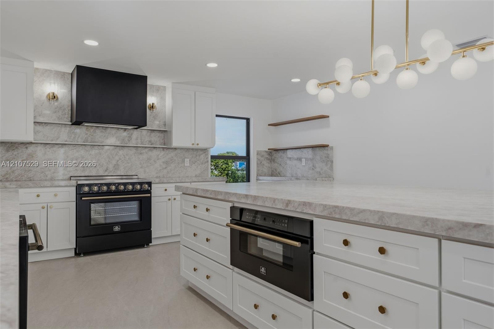 Kitchen featuring white shaker-style cabinetry, a contrasting matte black range hood, a dark finish freestanding range, and stone-surface countertops 