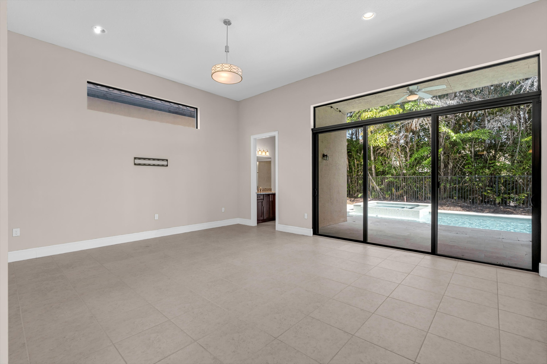 Spacious open-concept room flooded with natural light through expansive sliding glass doors and transom windows