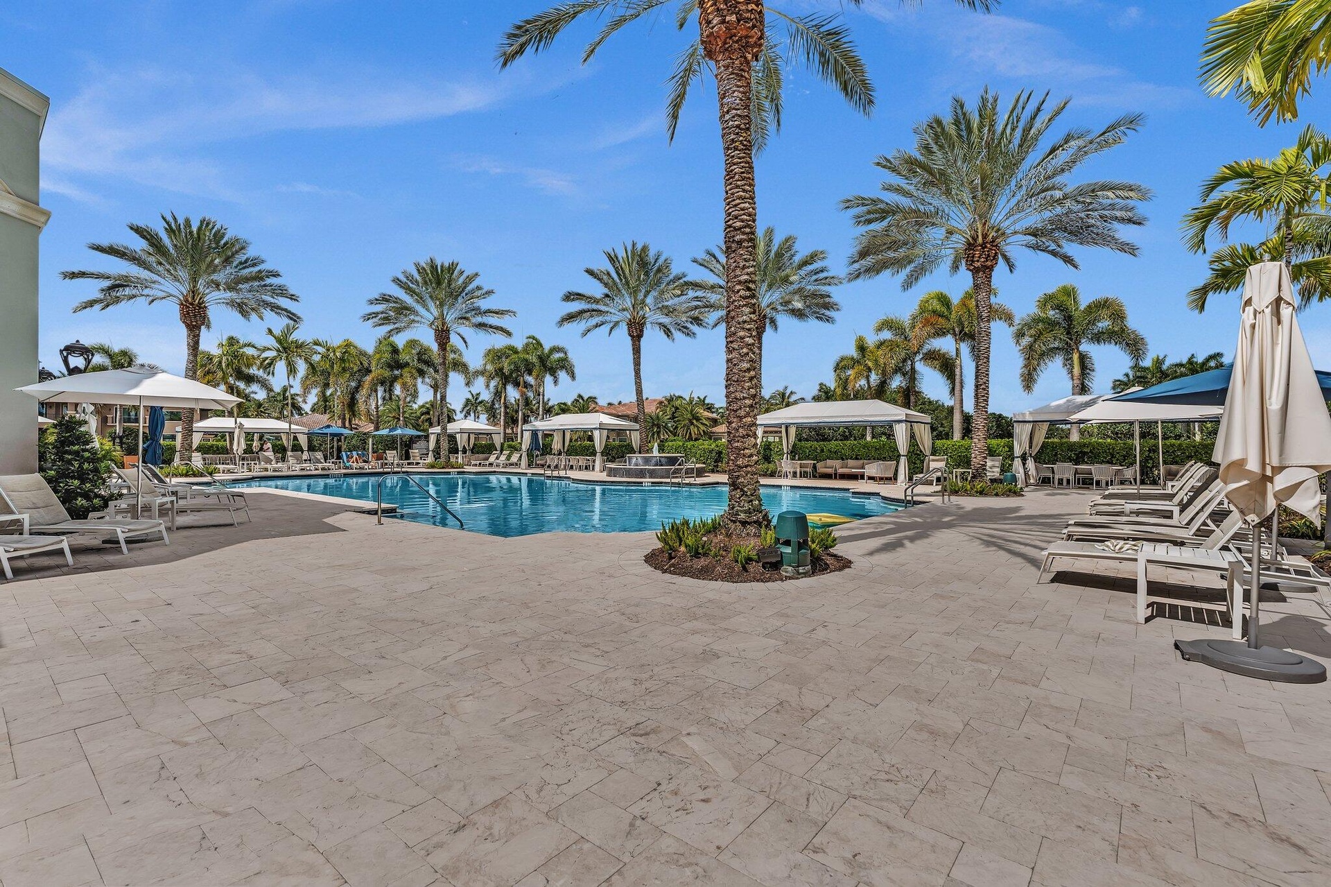 Large outdoor swimming pool with integrated spa and surrounding paver deck