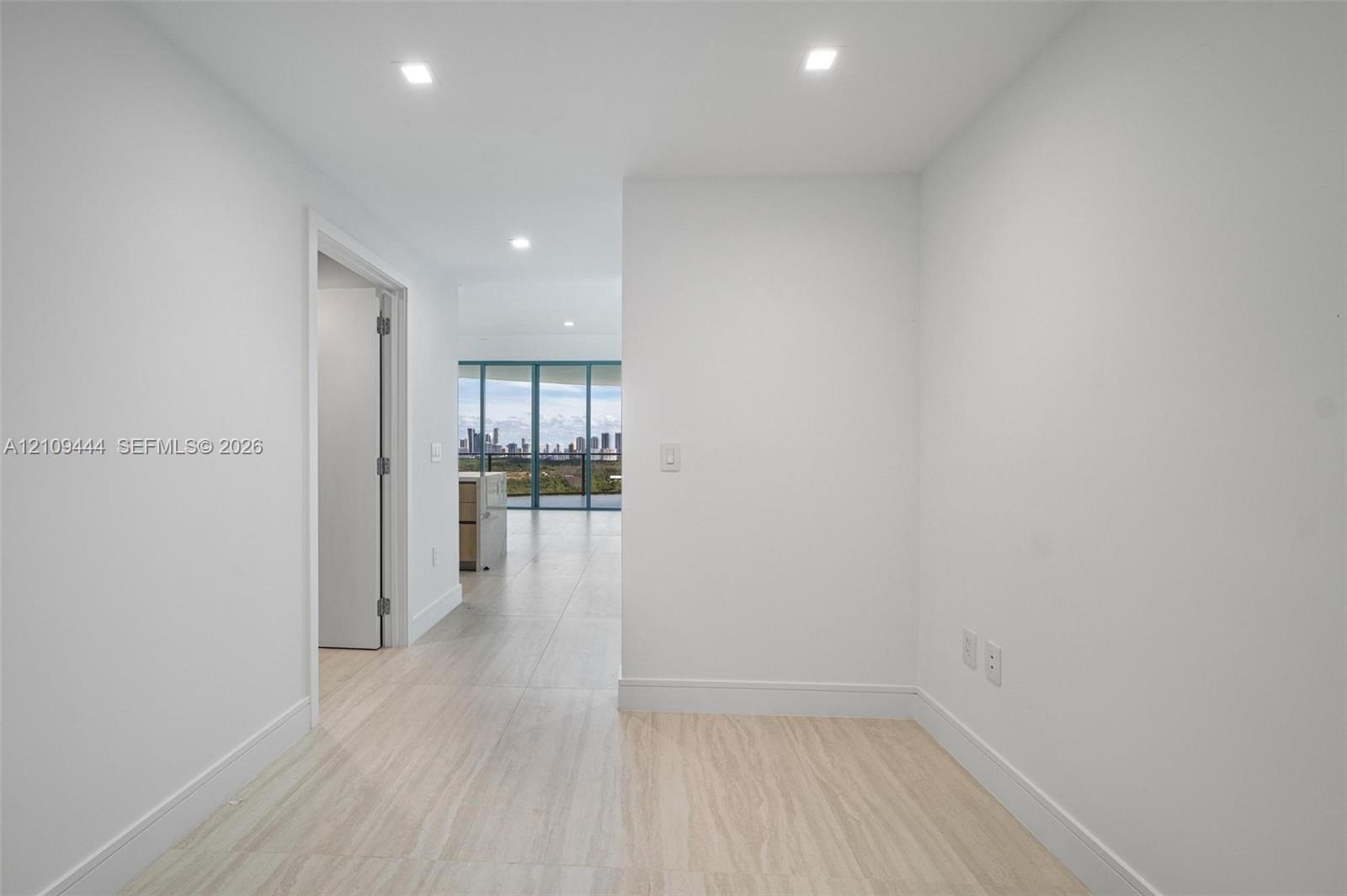 Interior space featuring large-format tile flooring, recessed lighting, and expansive floor-to-ceiling windows