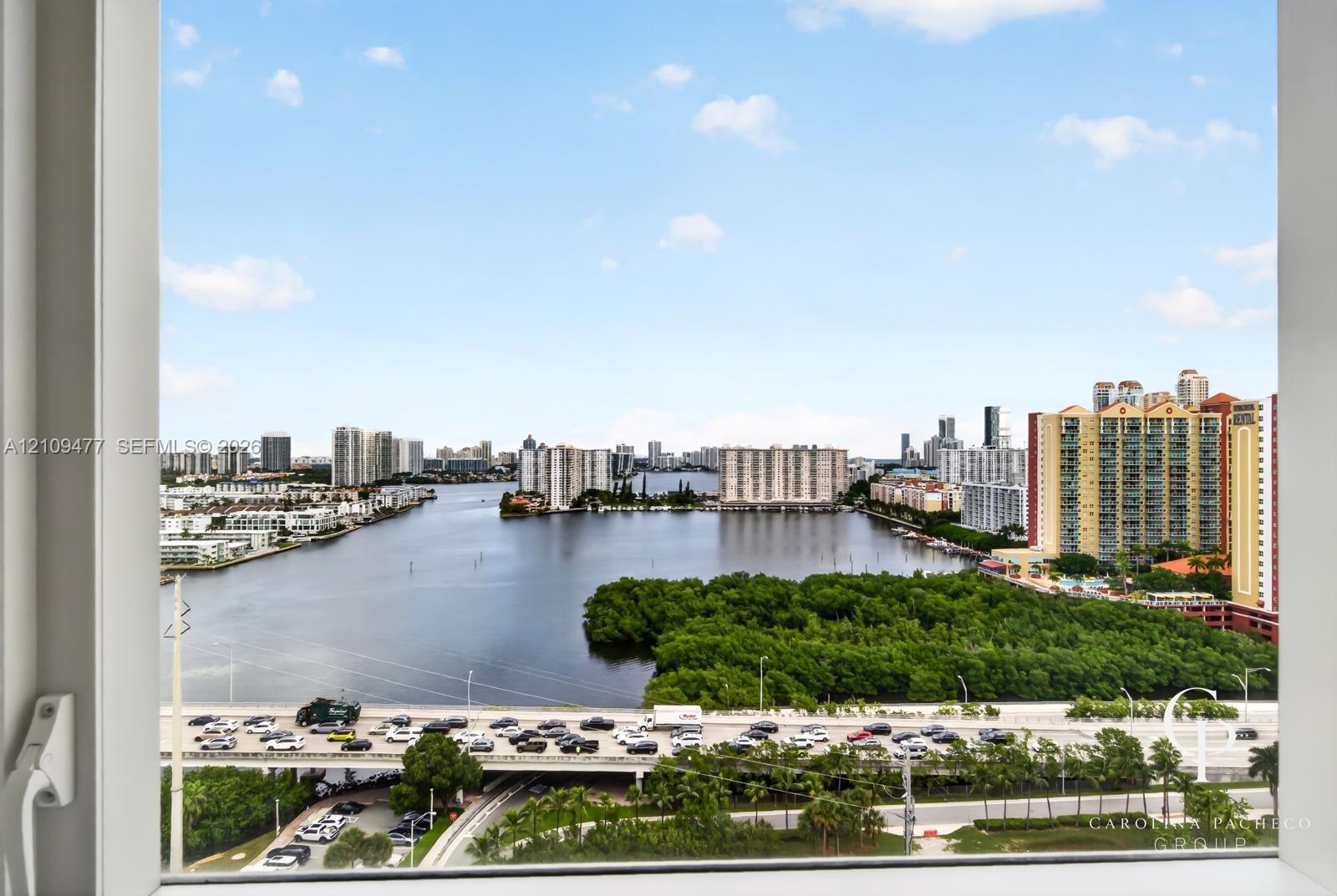 Panoramic water and cityscape scenery framed by a floor-to-ceiling window