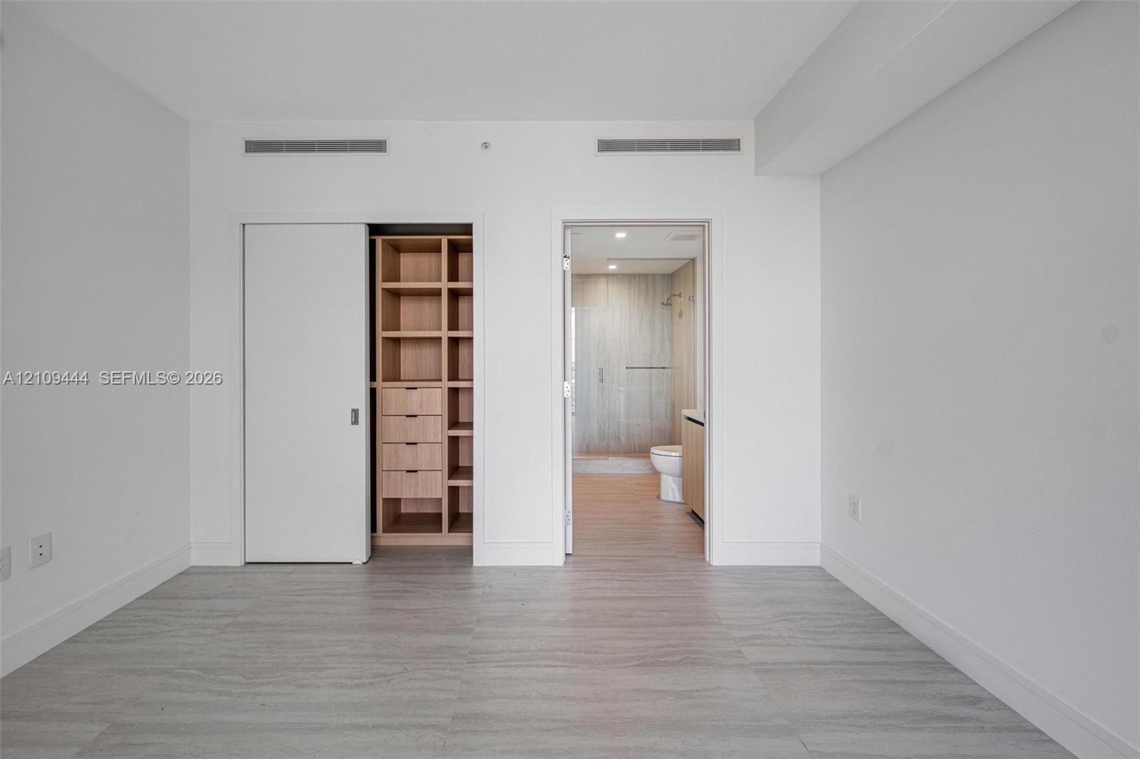 Wood-finish flooring, built-in closet system with shelving and drawers, and recessed lighting