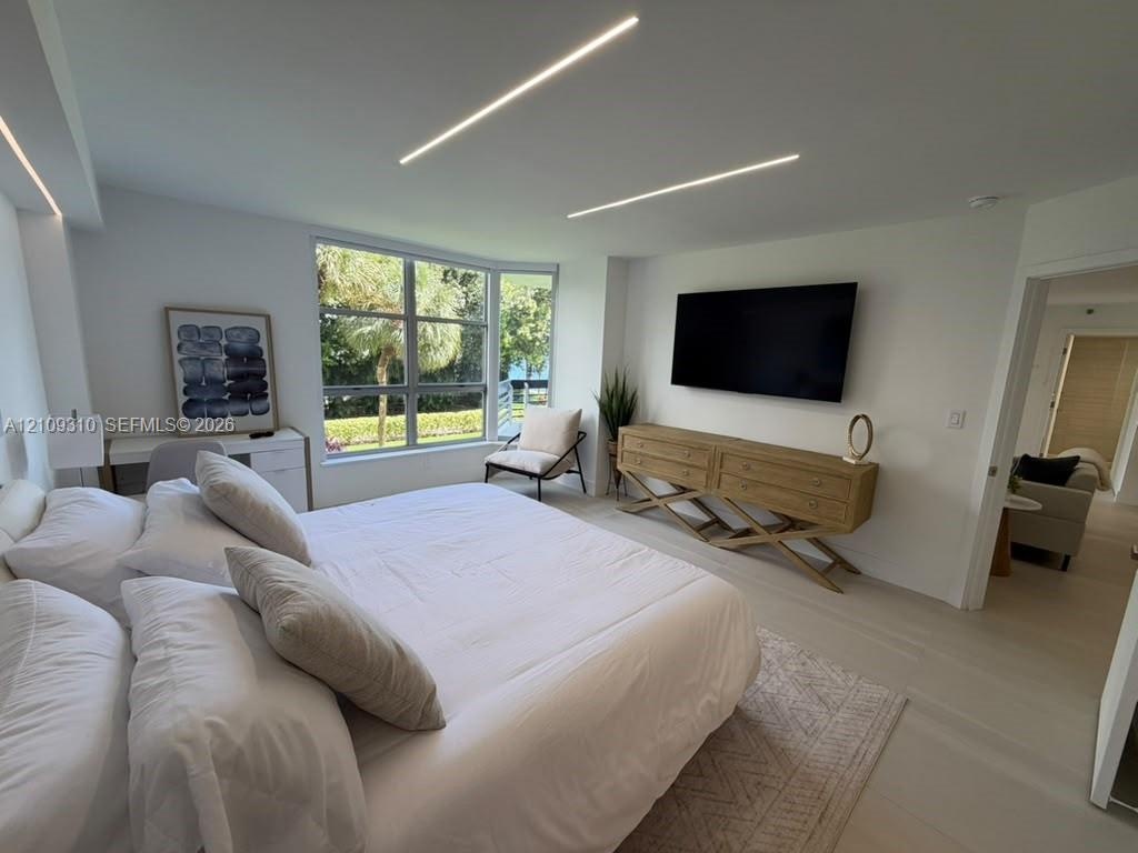 Neutral interior featuring recessed linear ceiling lighting, large-format tile flooring, and oversized windows