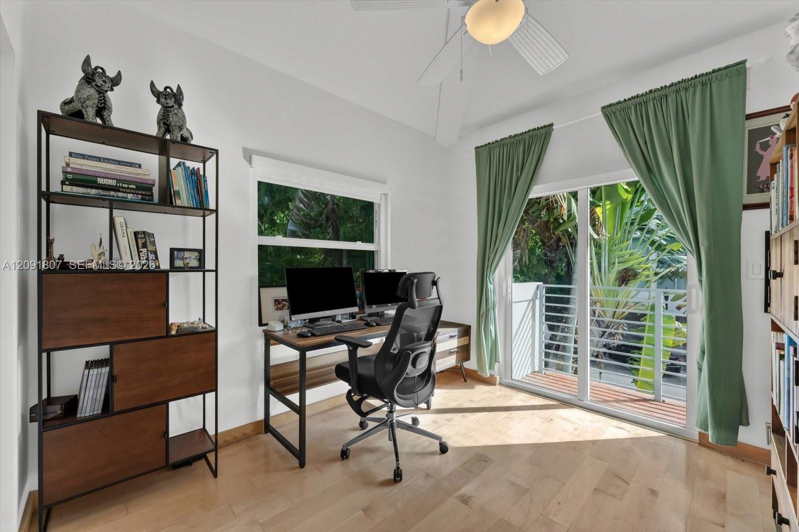 Room featuring light wood-finish flooring, a vaulted ceiling with a central integrated light fixture, a double-pane window, and a sliding glass door p
