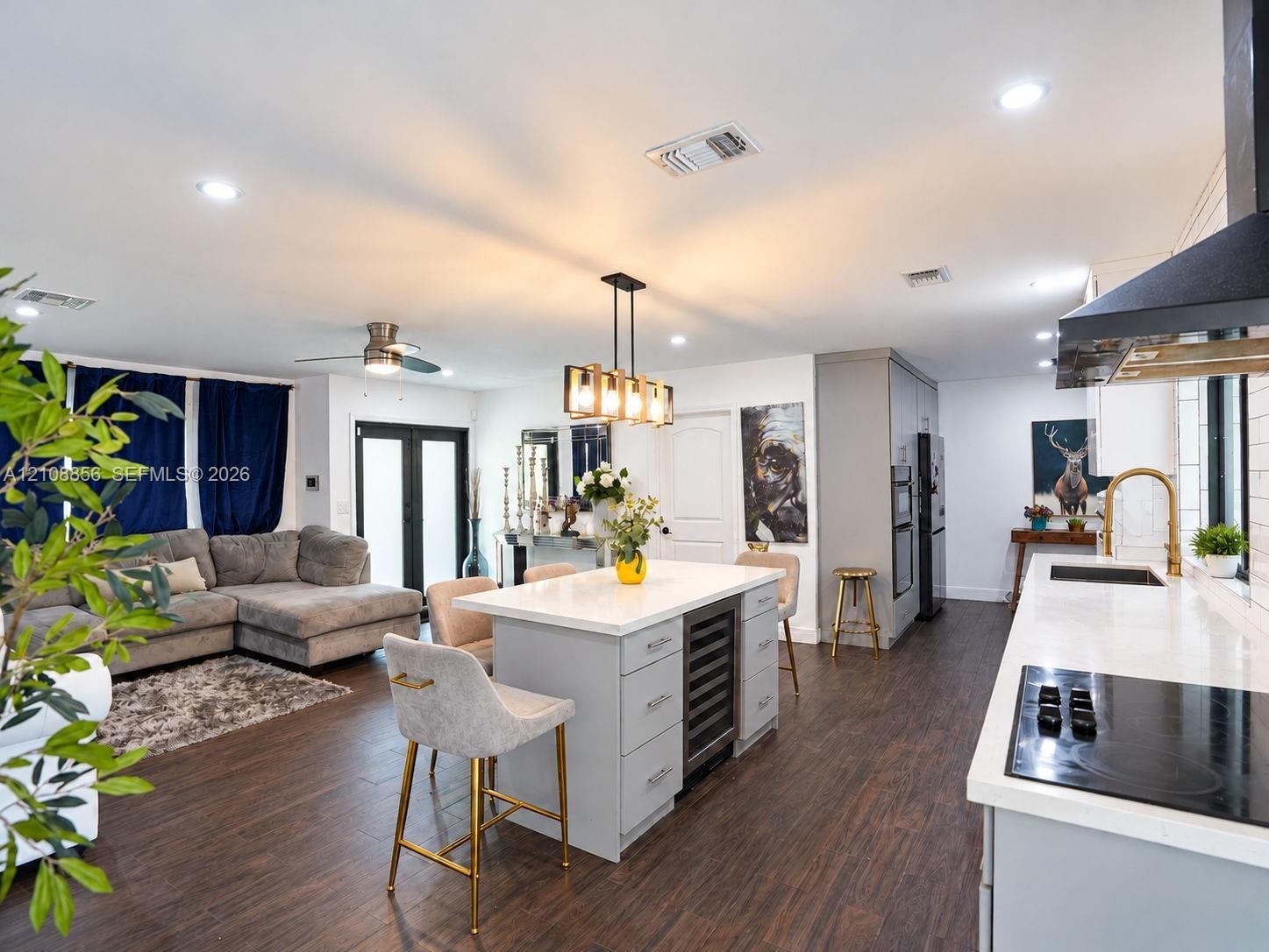 Kitchen featuring a central island with a built-in wine refrigerator, quartz countertops, wood-finish flooring, recessed lighting, and a modern indust