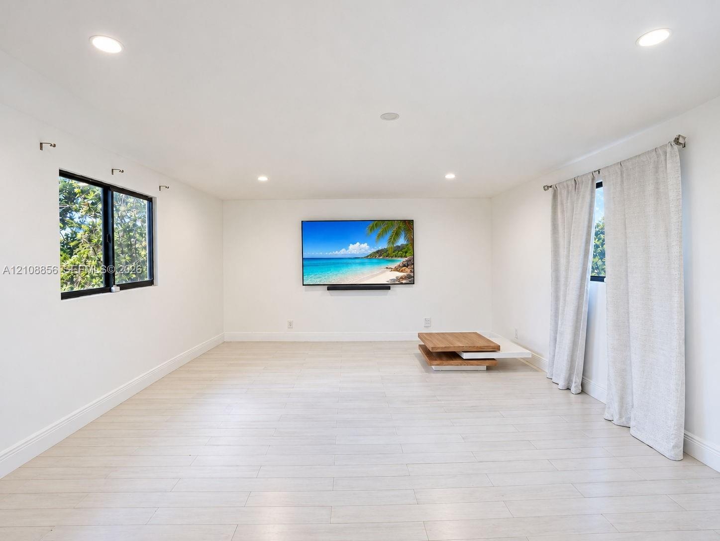 Bright interior space featuring wood-finish flooring, recessed lighting, and black-framed windows