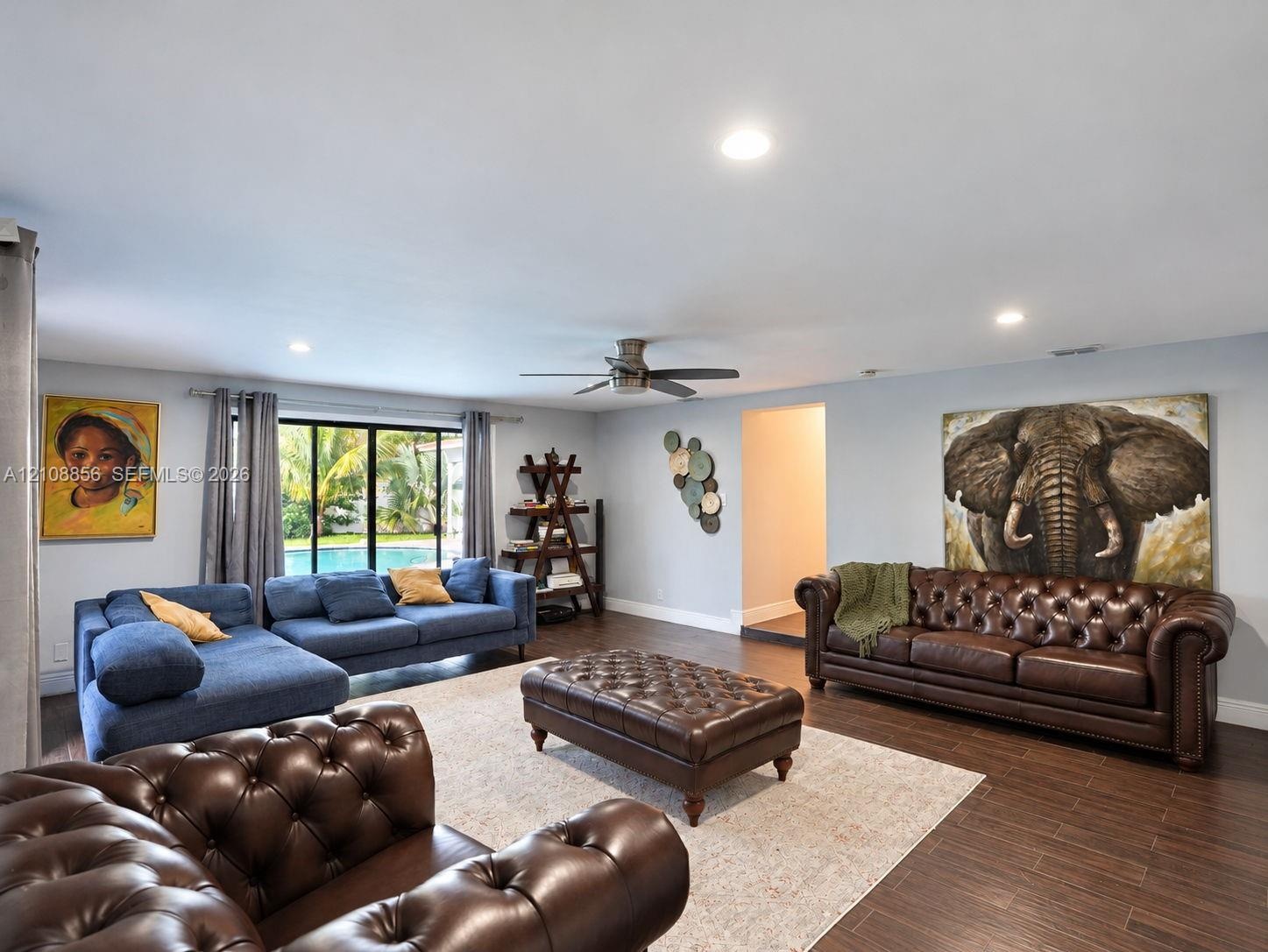 Open-concept living space featuring wood-finish flooring, recessed lighting, and a ceiling fan