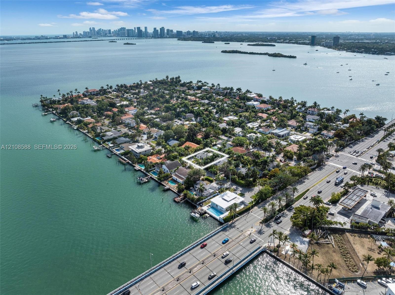 Aerial perspective of a residential parcel situated on a peninsula, characterized by mature tree canopy and proximity to coastal waters
