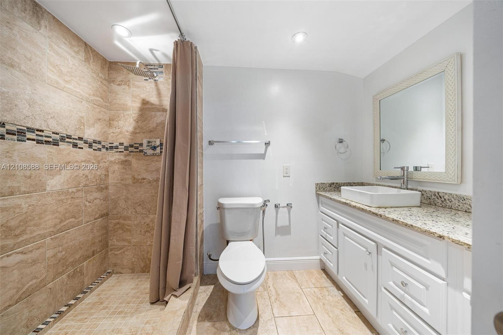 2nd -Bathroom featuring a walk-in shower with stone-tile surround, mosaic tile inlay, white vanity with stone countertop, rectangular vessel sink, and
