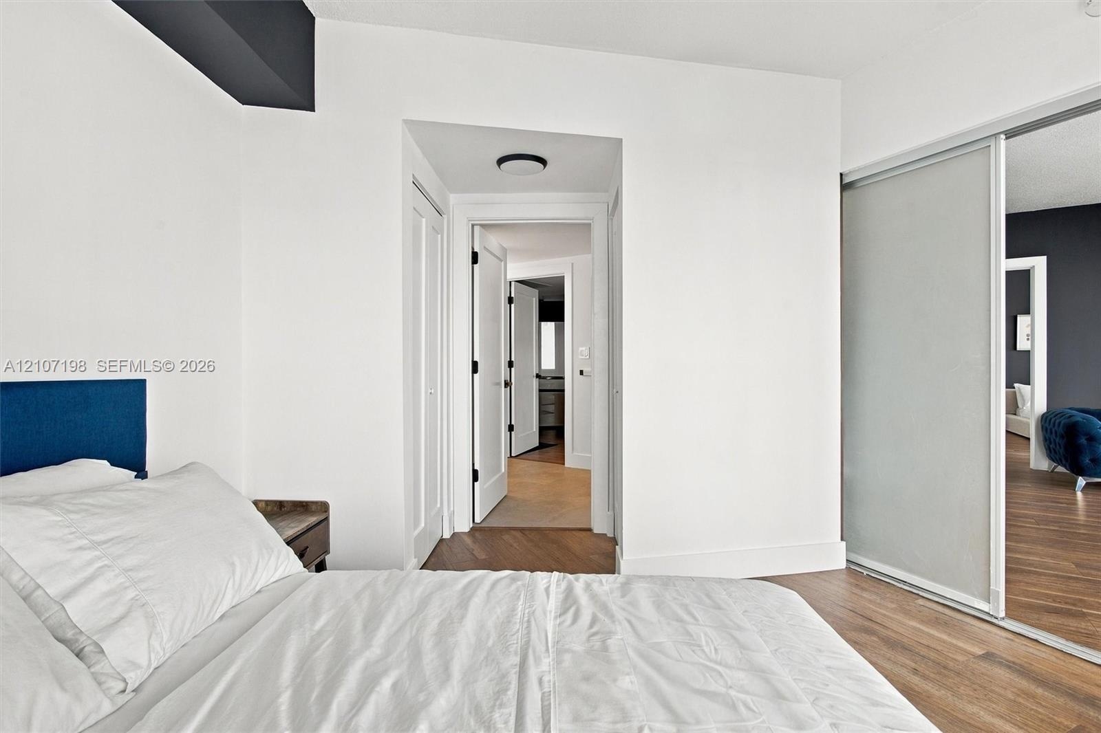 Sliding closet doors with frosted panels, wood-finish flooring, and recessed ceiling lighting
