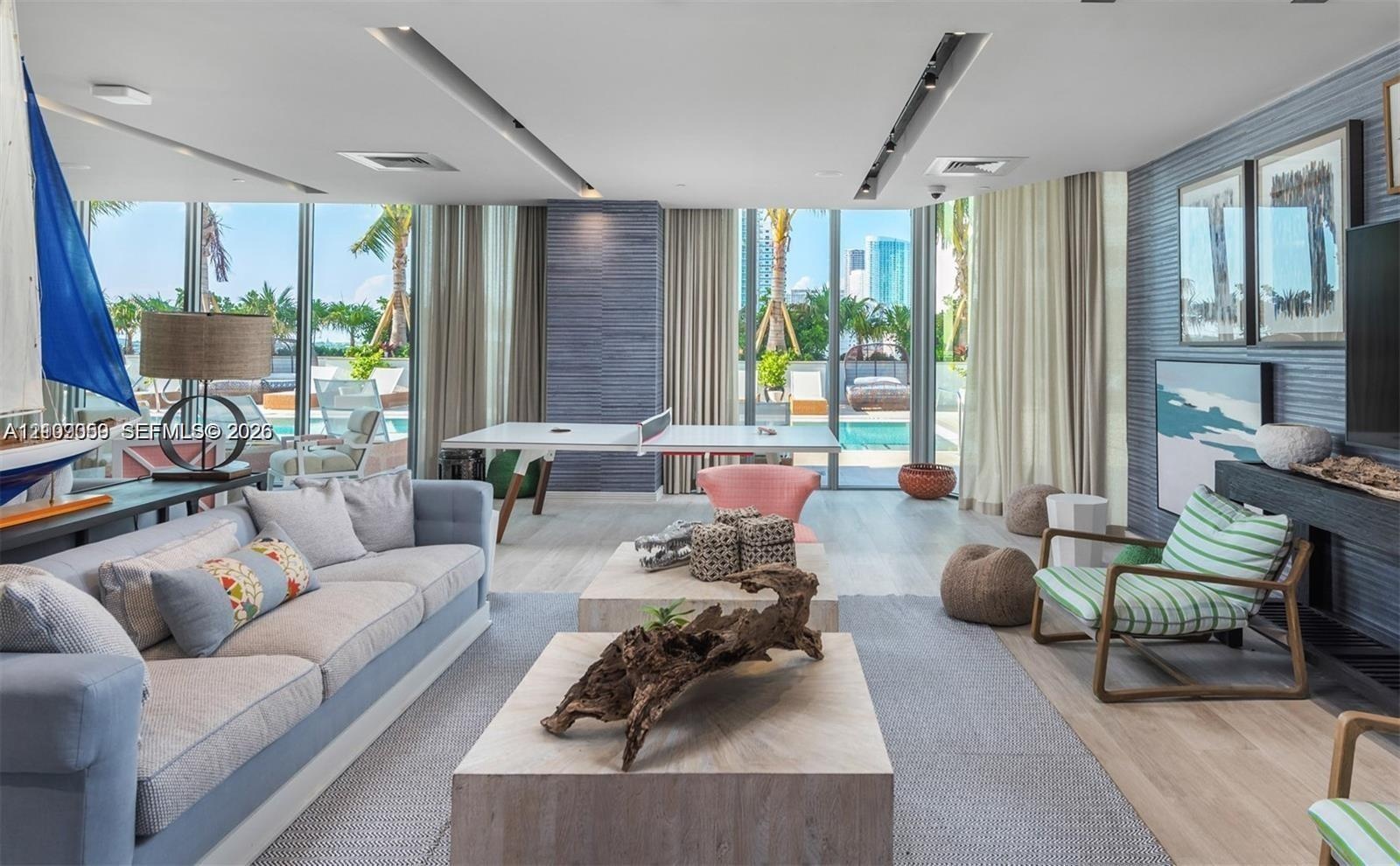 Floor-to-ceiling glass walls, recessed linear lighting, textured wall treatments, wood-finish flooring, and built-in shelving unit