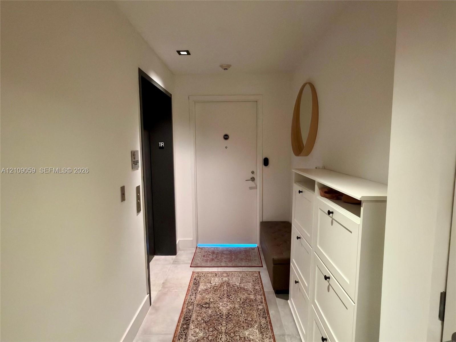 Foyer featuring large-format tile flooring, recessed ceiling lighting, and a solid-core entry door