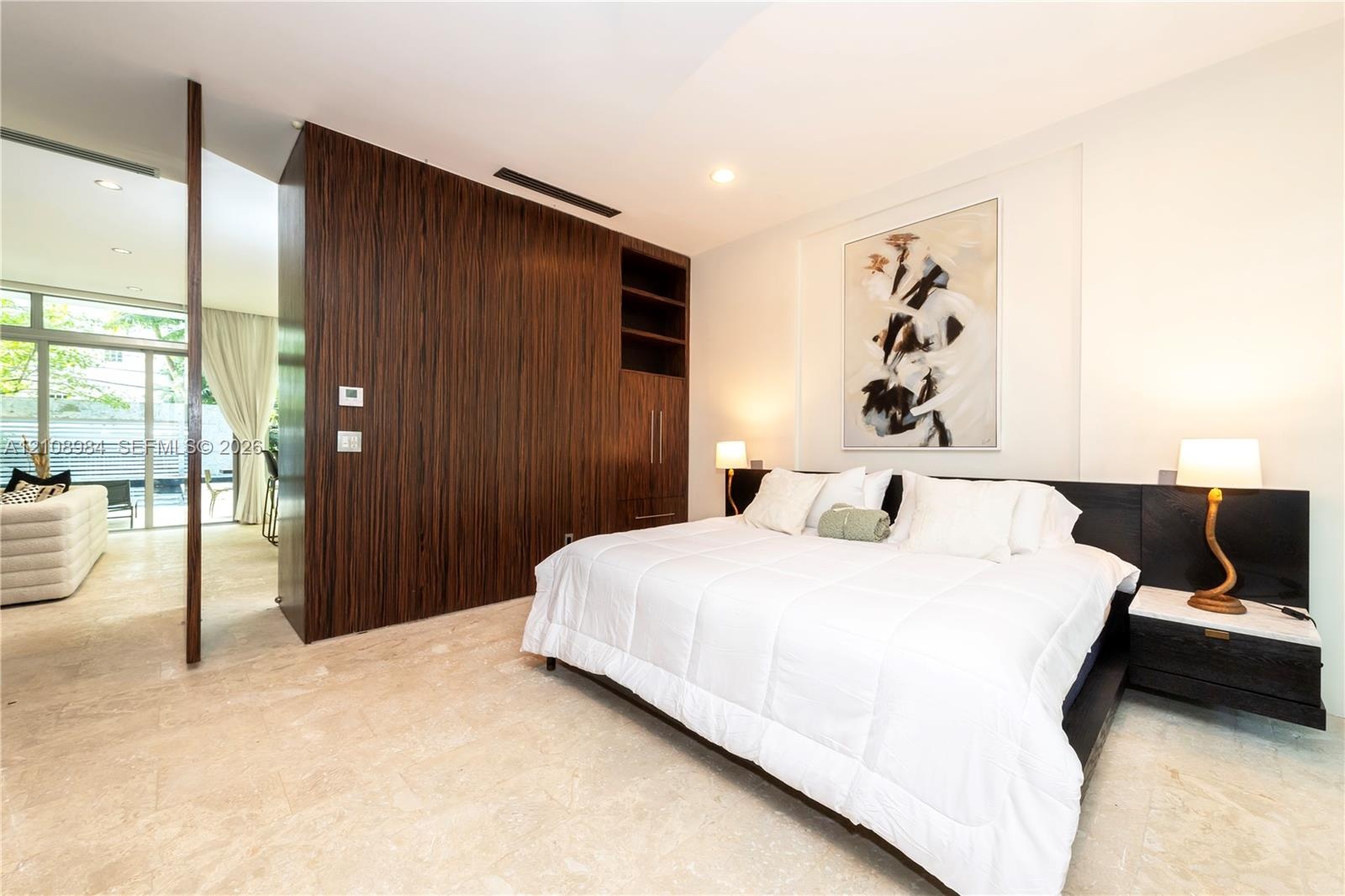 Natural stone flooring, floor-to-ceiling wood-finish custom cabinetry, recessed lighting, and wall-mounted electrical fixtures